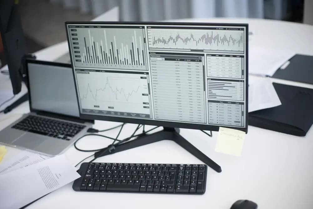 Desk with monitors showing data charts