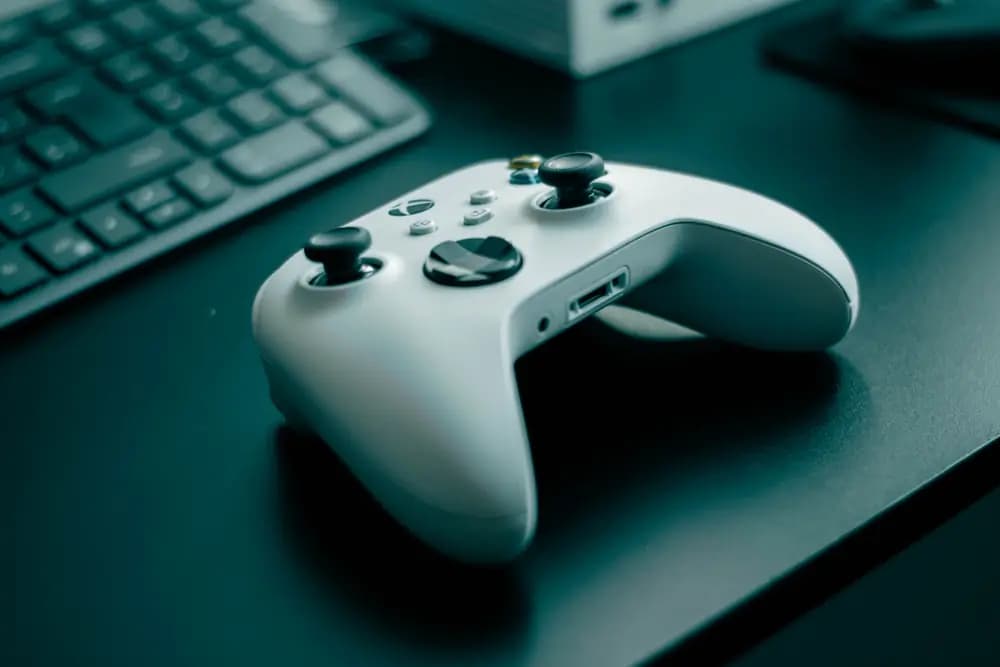 Game controller on a desk next to a keyboard