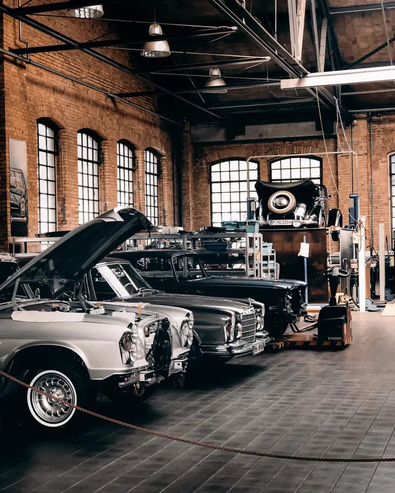 Classic cars in a historic brick workshop hall